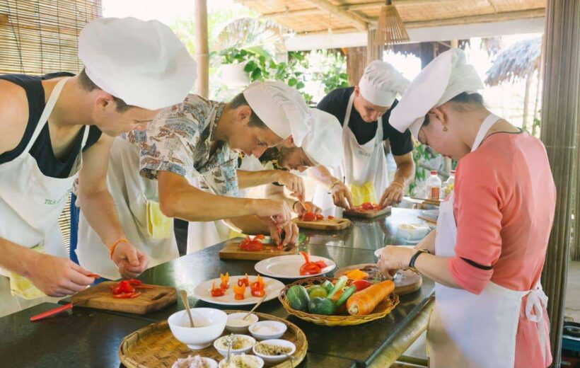 Touristes en train de prendre un cours de cuisine au Vietnam